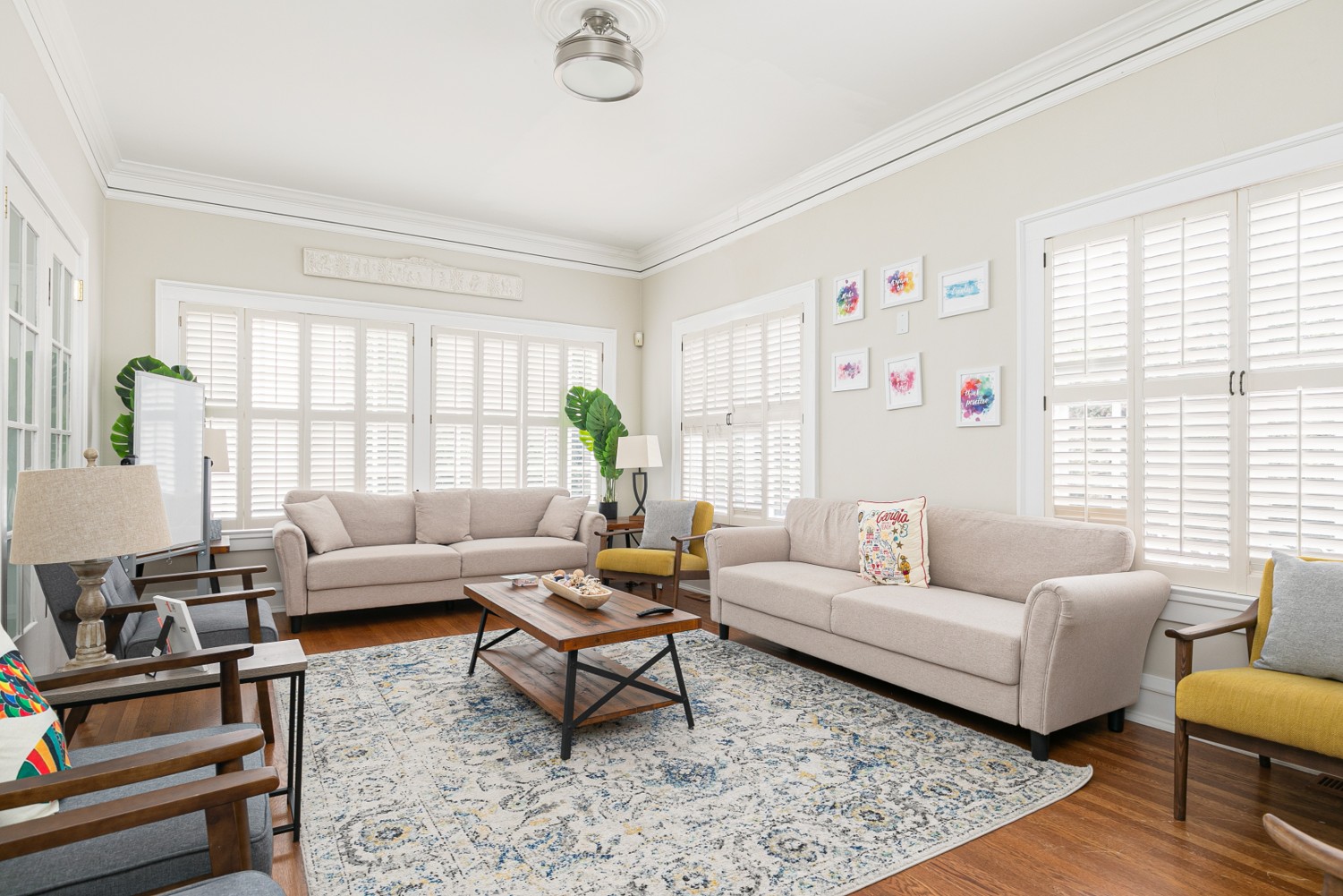 Bright lounge with two beige sofas and armchairs