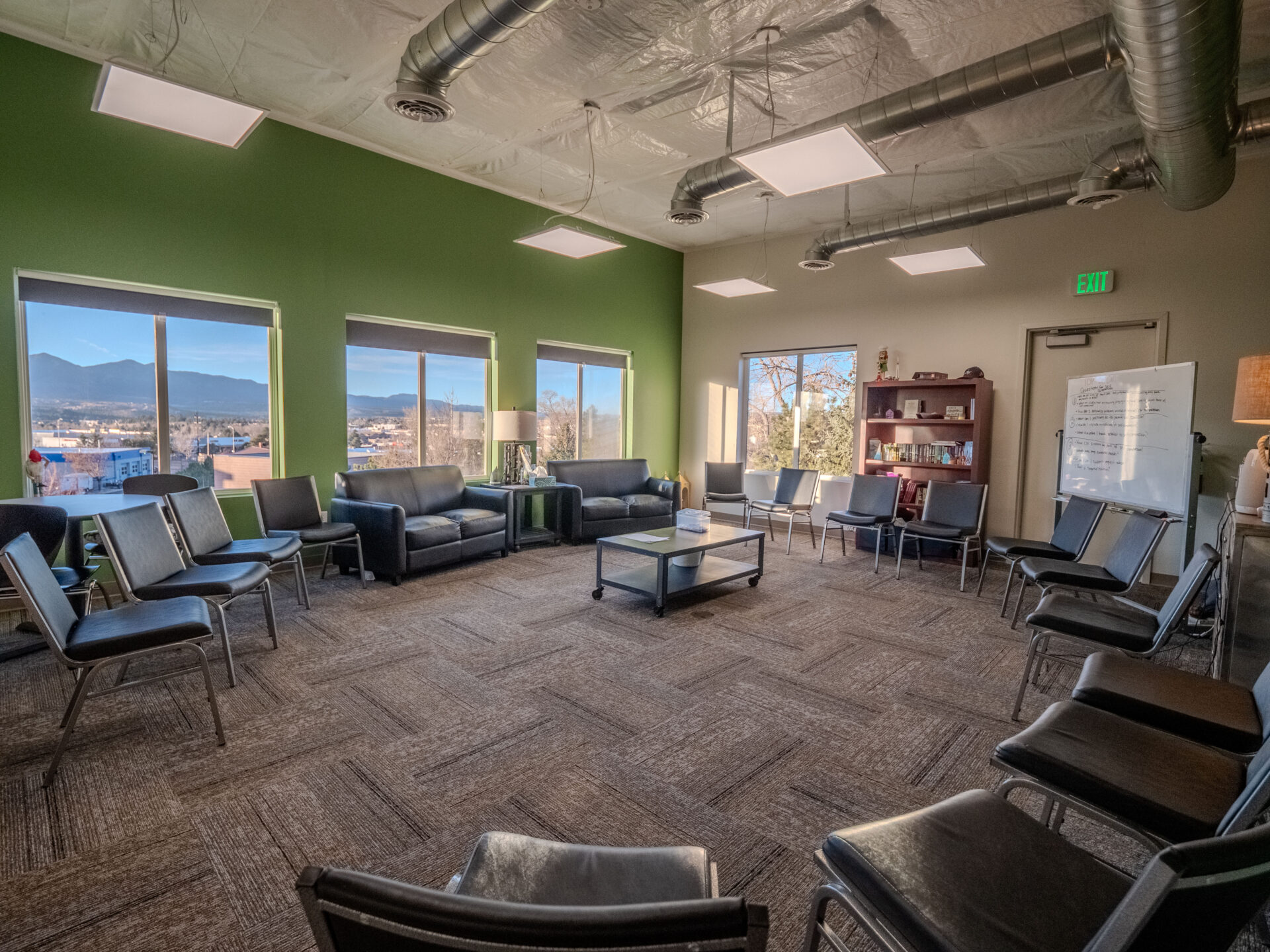Circle of chairs in a bright therapy room with mountain views