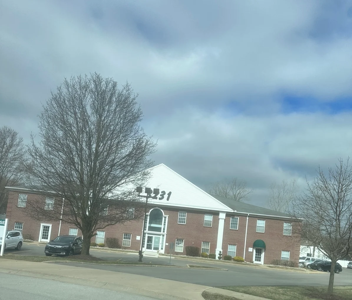 Brick building with “3231” address sign under cloudy sky