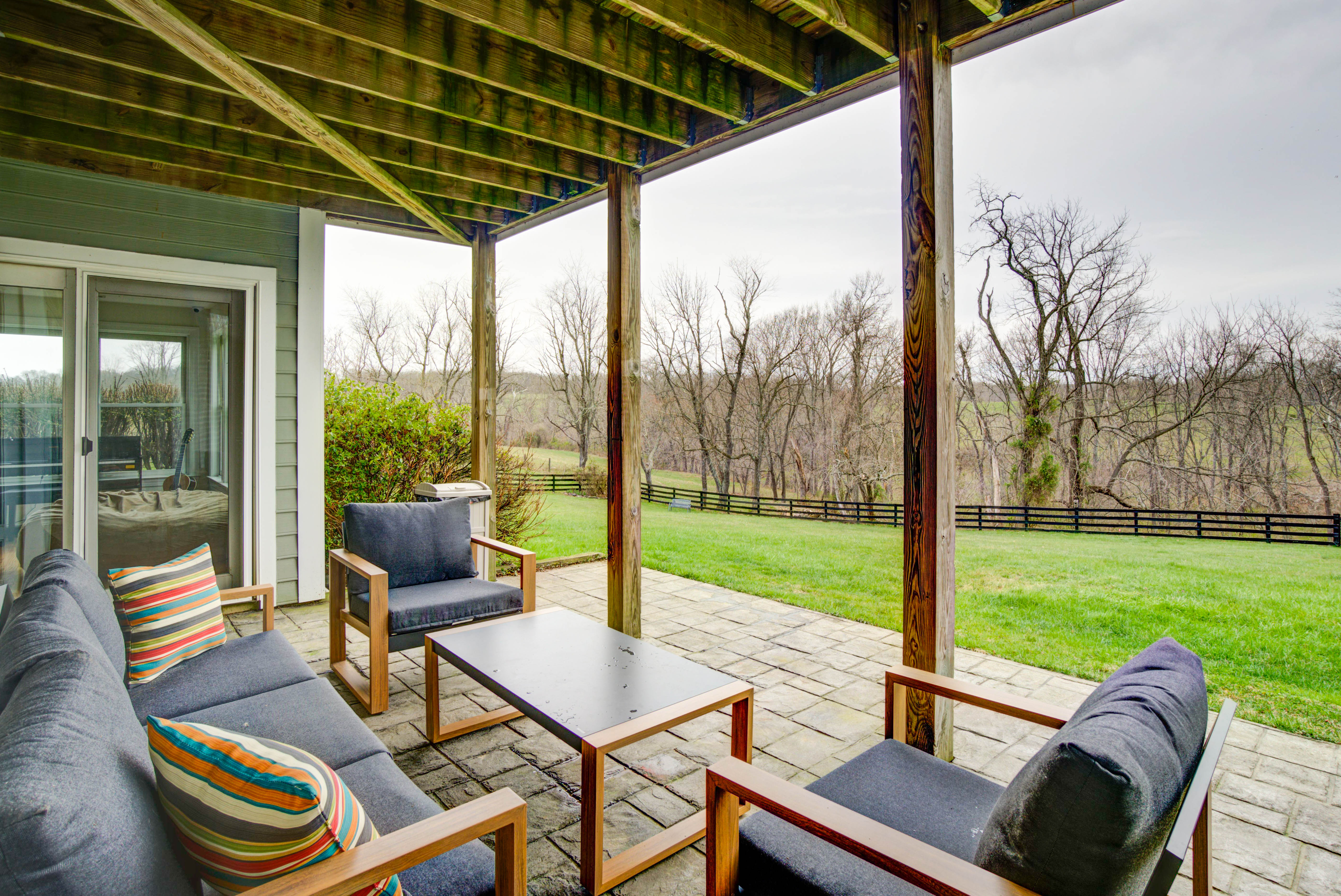 Outdoor seating on covered patio with green lawn view