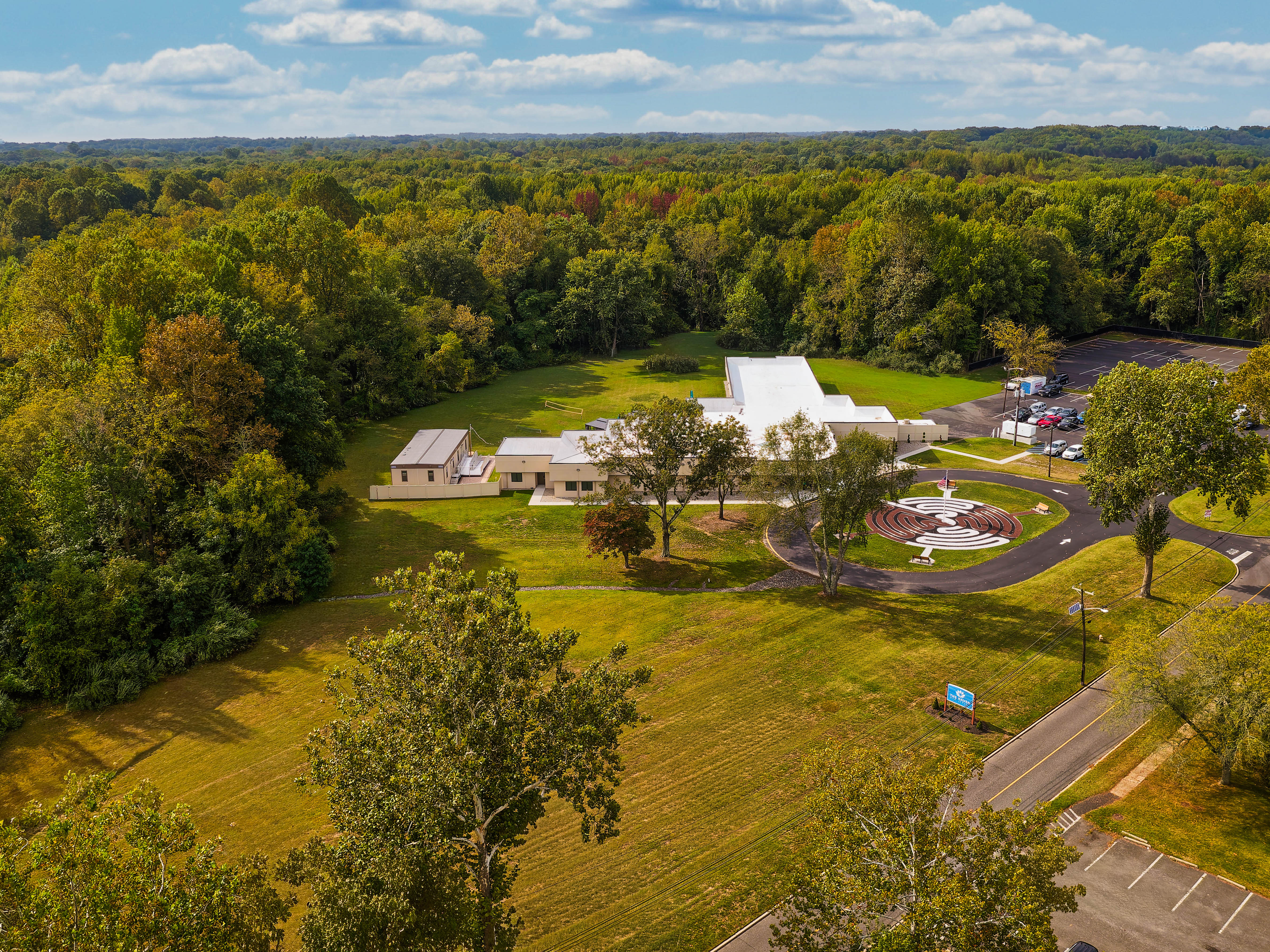 Aerial view of rehab facility surrounded by open fields and trees.