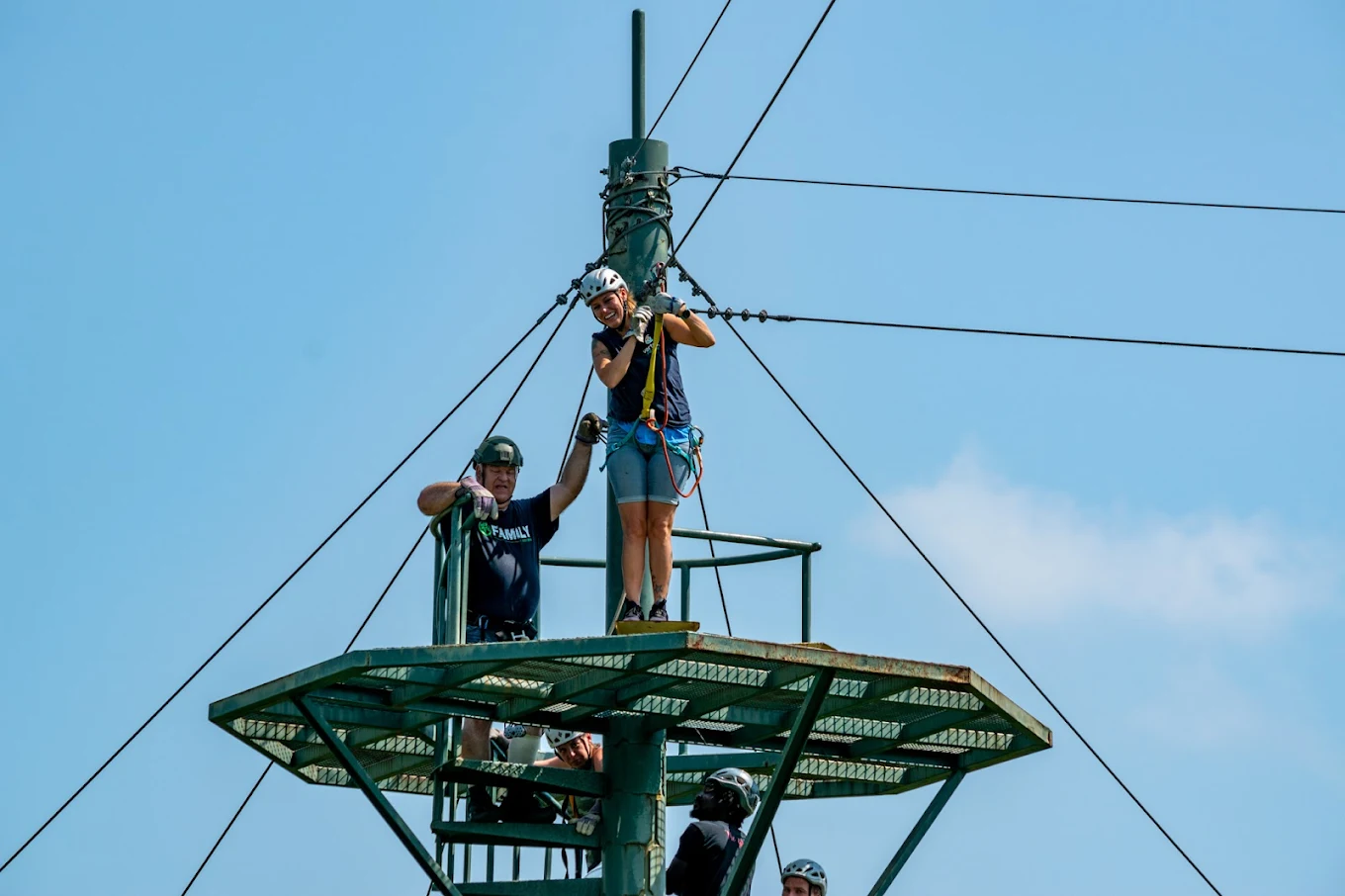 People on zip line platform wearing safety gear
