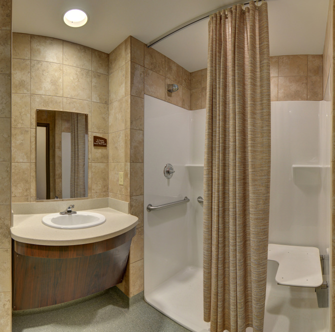 Bathroom with shower, sink, and tile walls