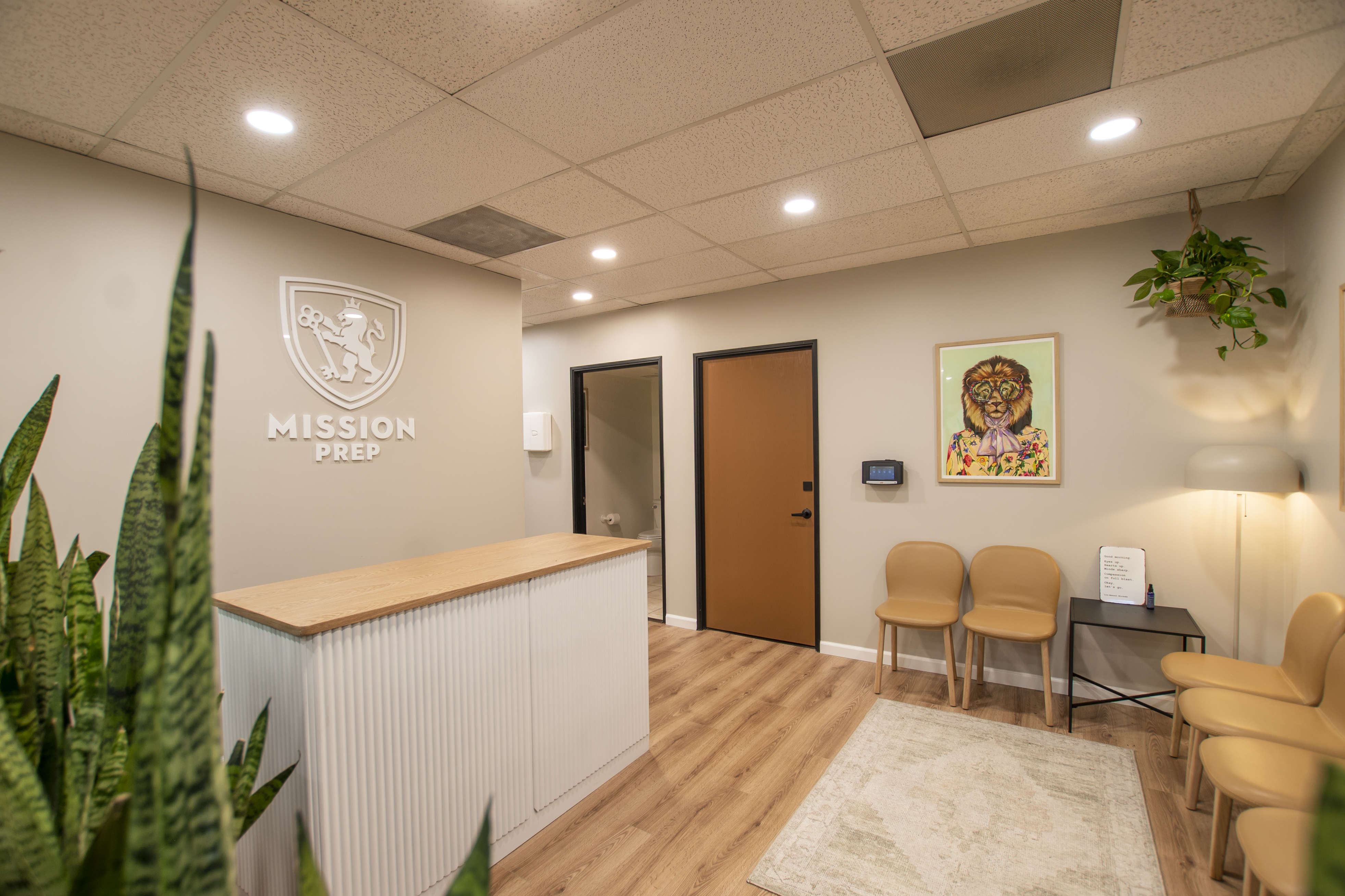 Reception area with a wooden desk and "Mission Prep" logo on the wal