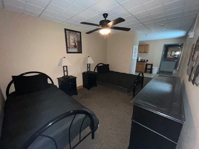 Shared bedroom with two twin beds and simple furnishings.