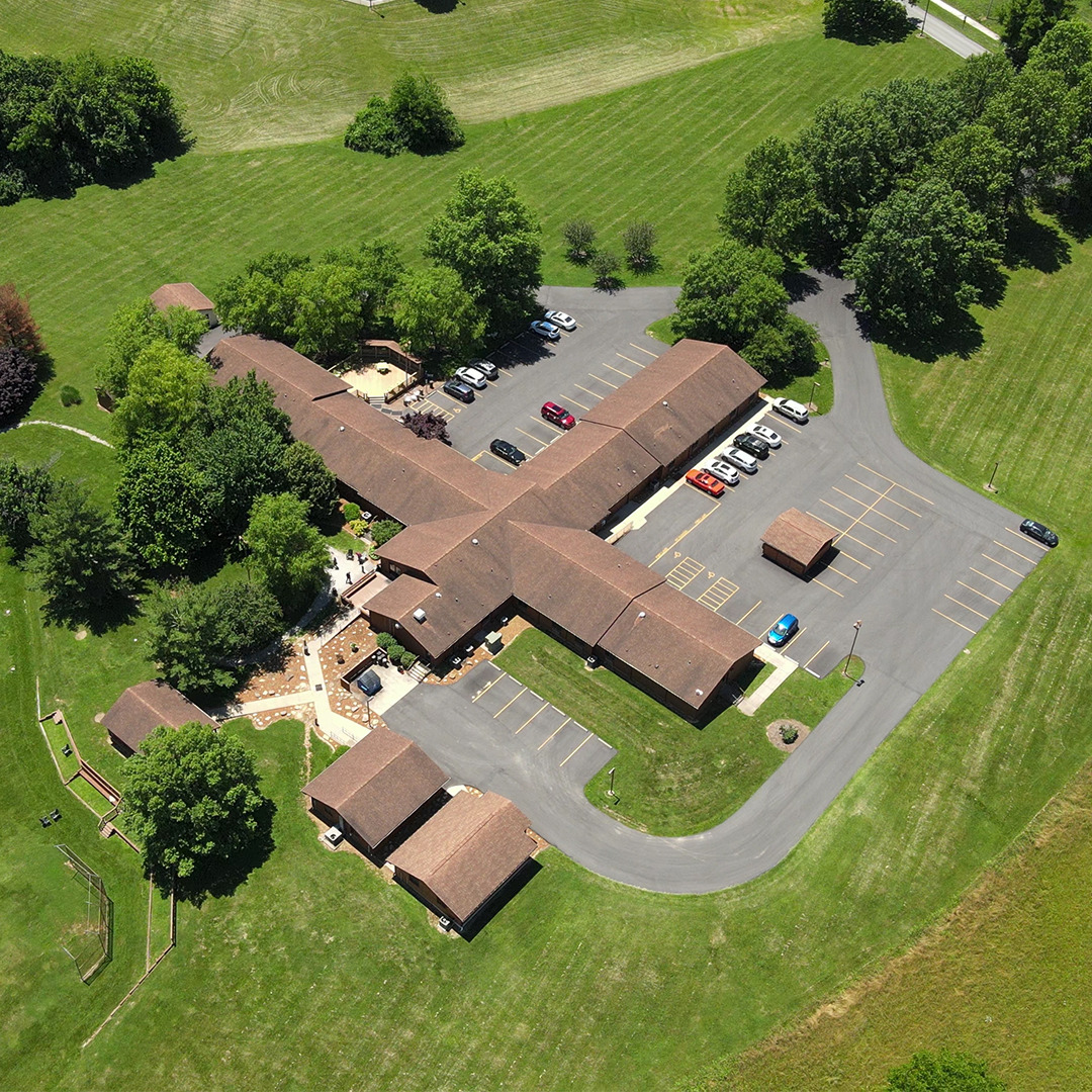 Overhead image of large treatment campus with multiple connected buildings and green open fields.