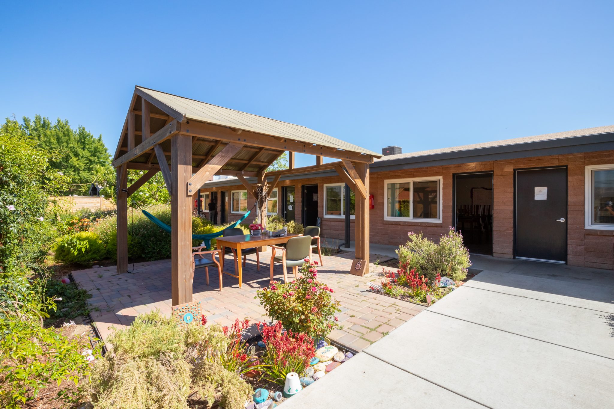 Covered outdoor lounge with seating and garden area
