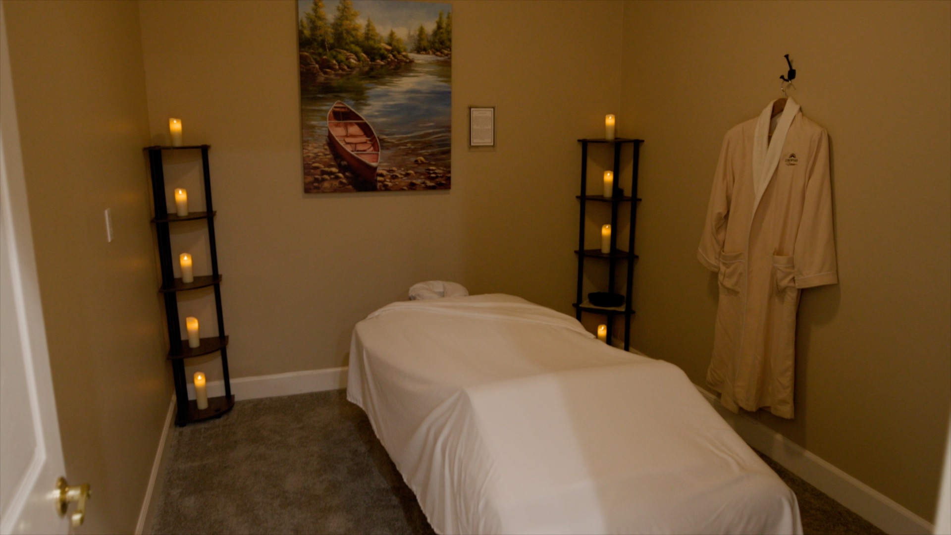 Massage room with treatment table, candles, and robe