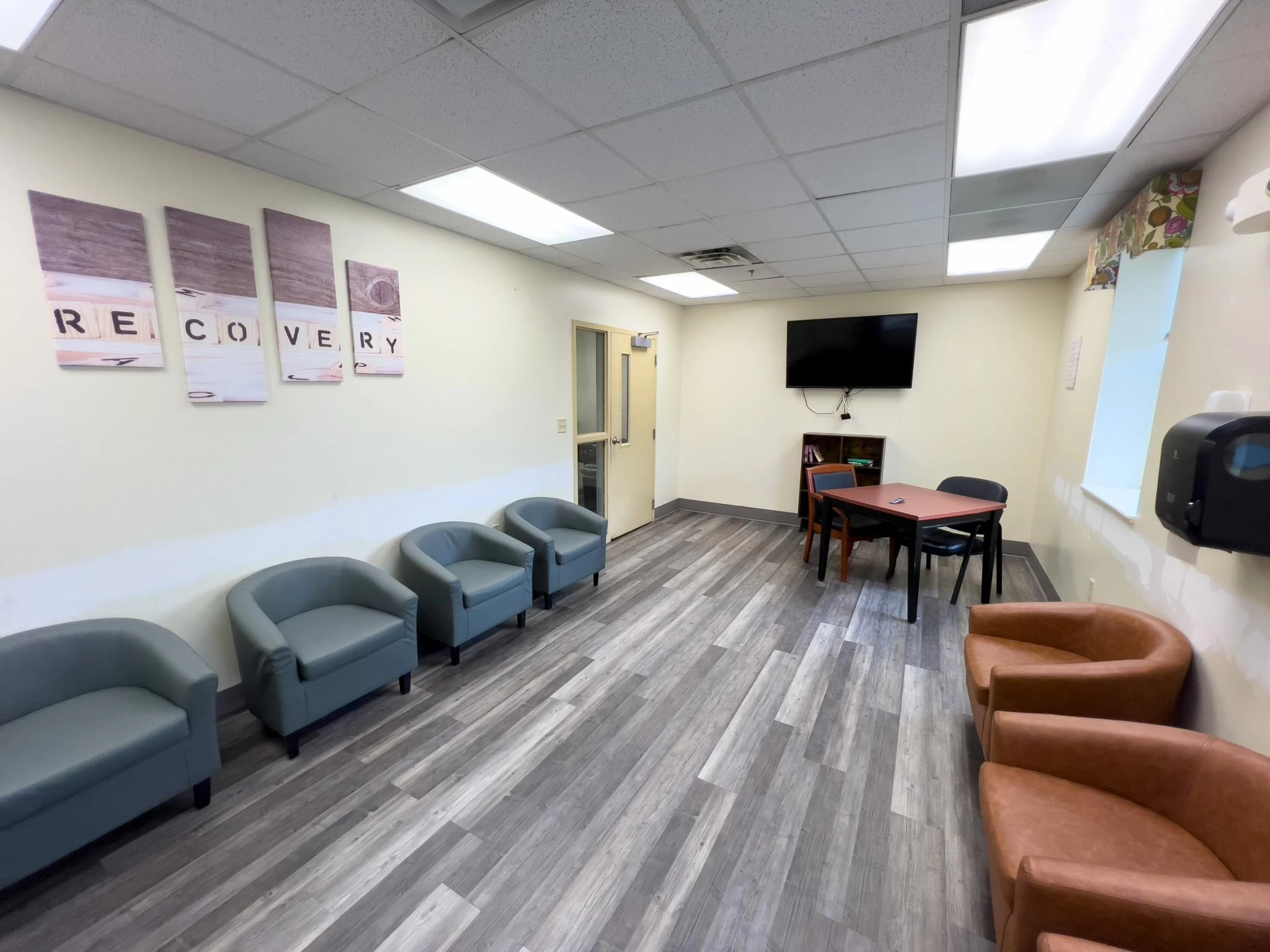 Lounge space with TV and armchairs for guests