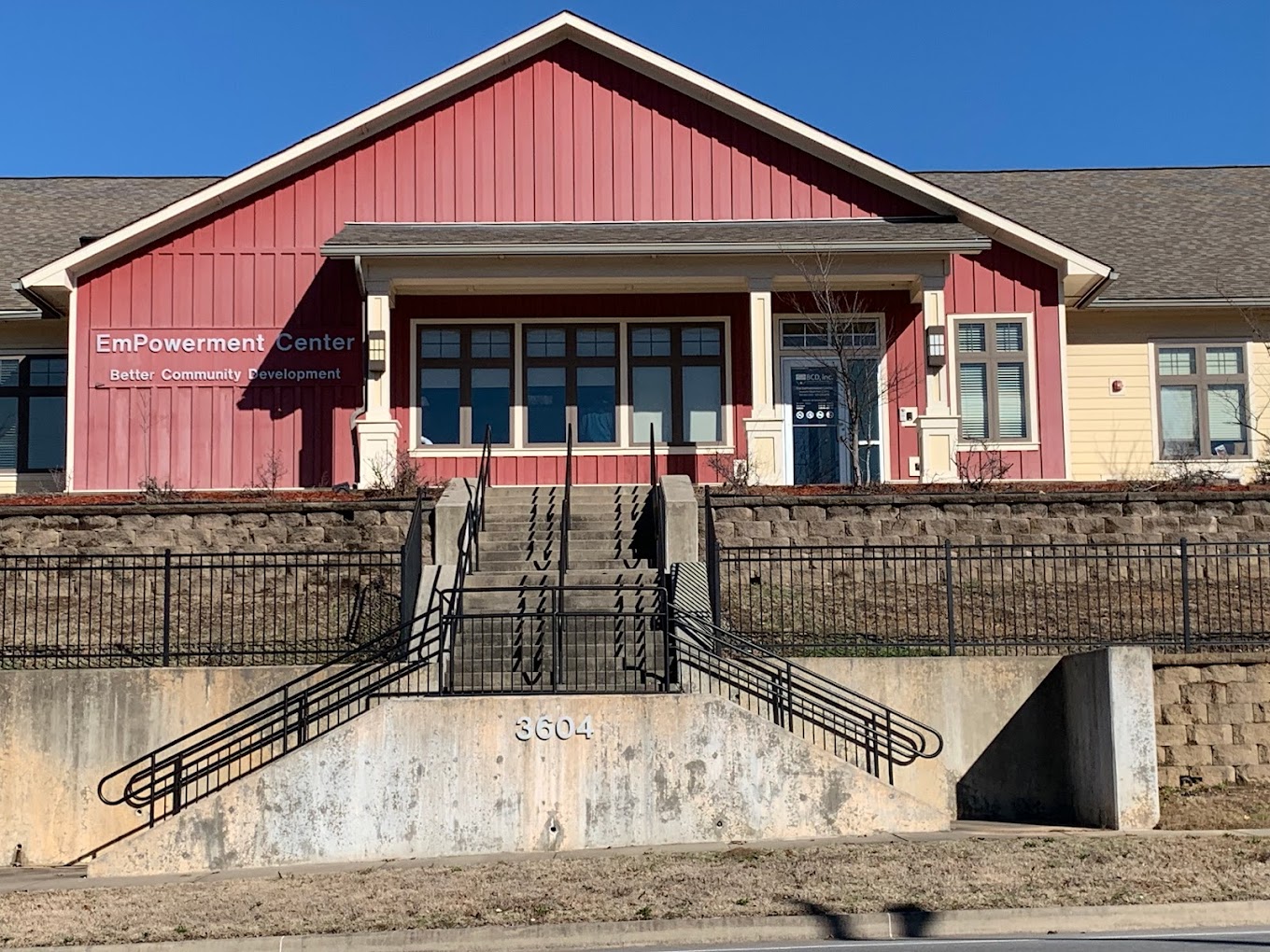 EmPowerment Center by Better Community Development Inc. with a red facade and stairs leading up to the entrance.