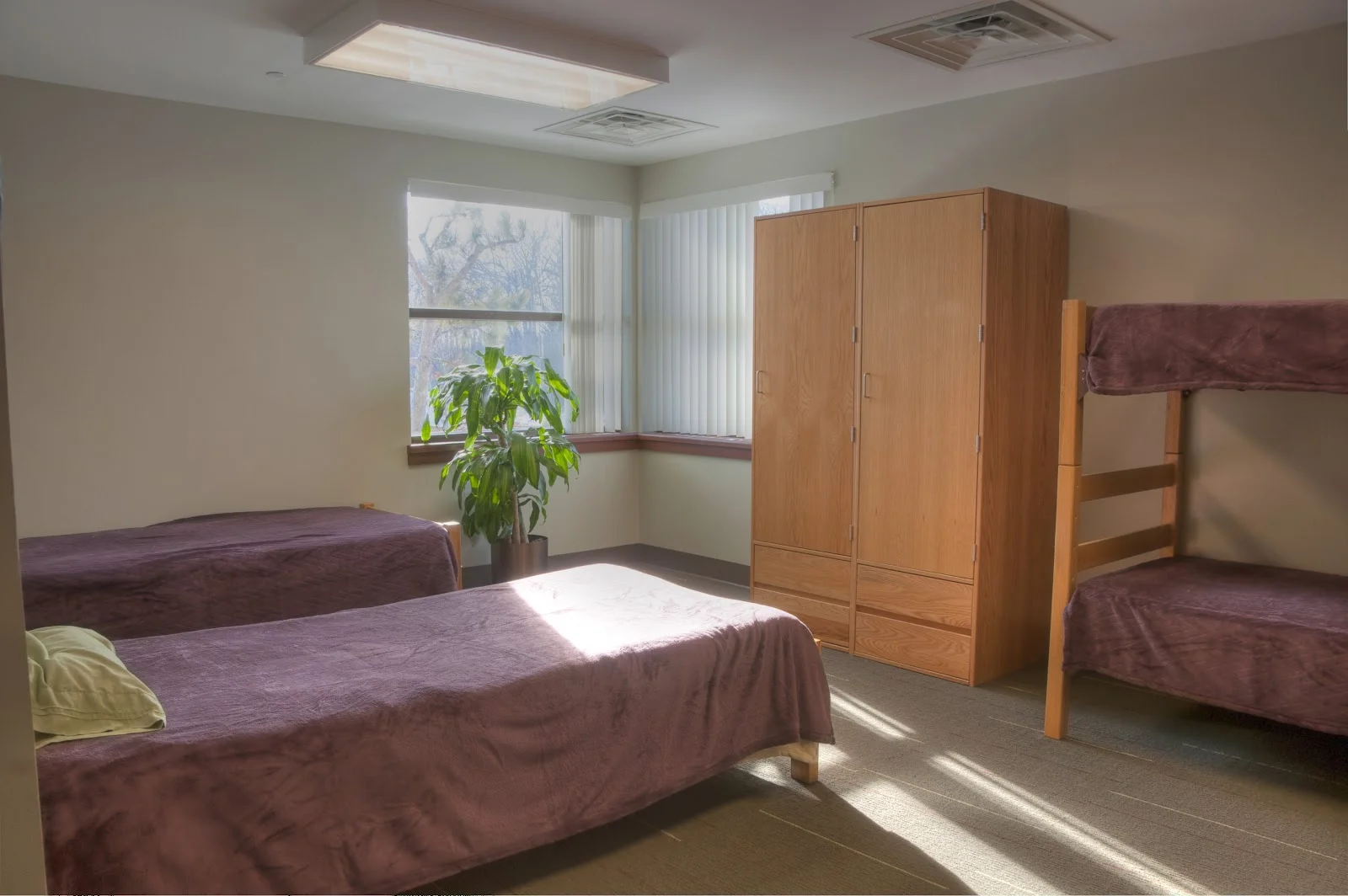 Shared bedroom with beds, bunk, and wooden wardrobe