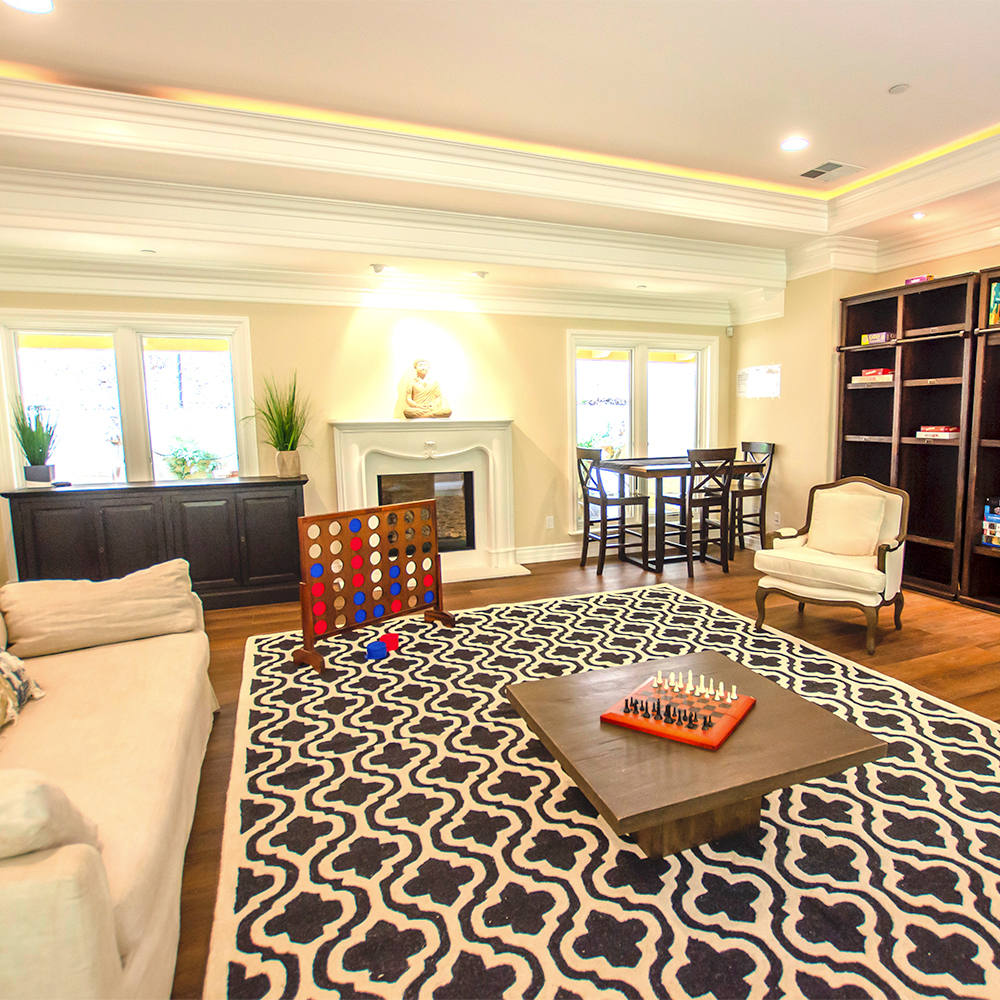 Living room with games and a fireplace.