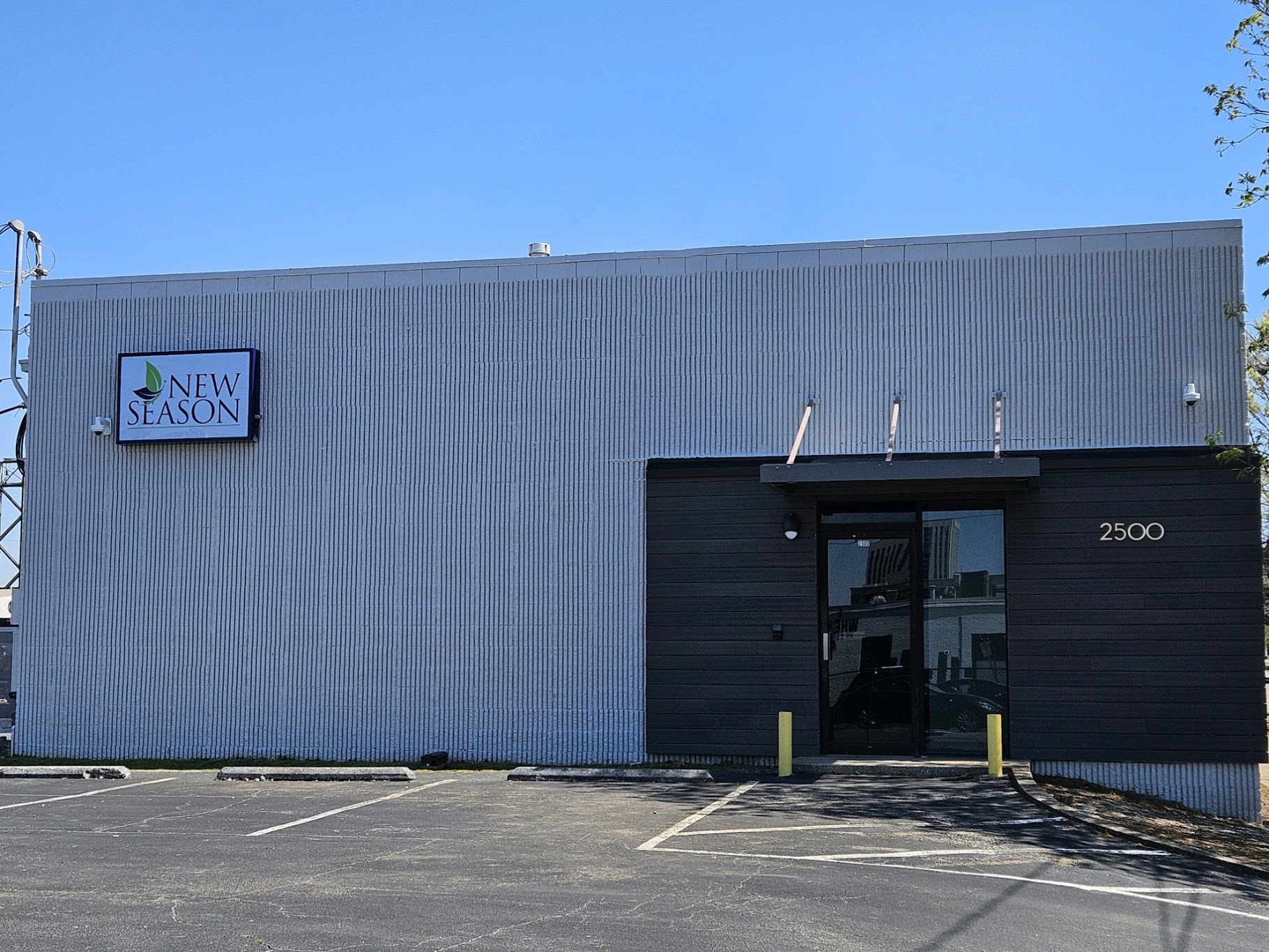 Modern gray building with New Season sign and address number 2500