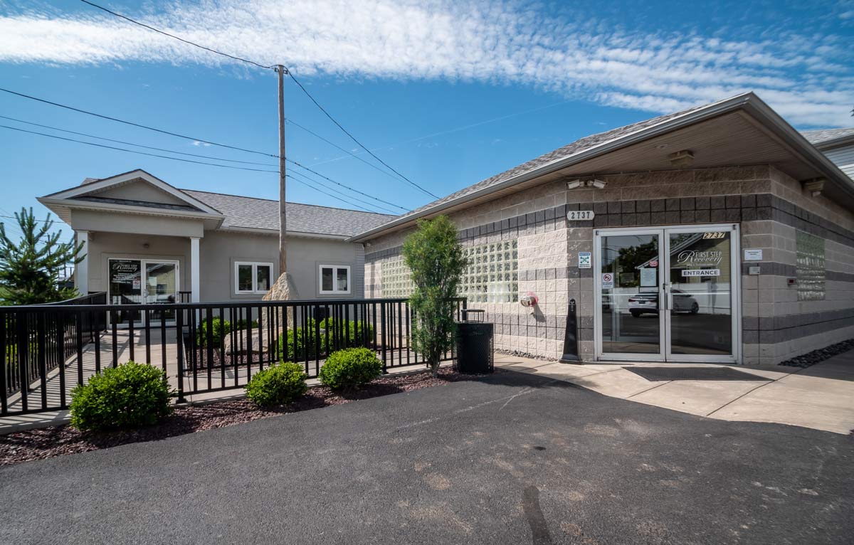 Front of facility with glass doors and landscaped entry