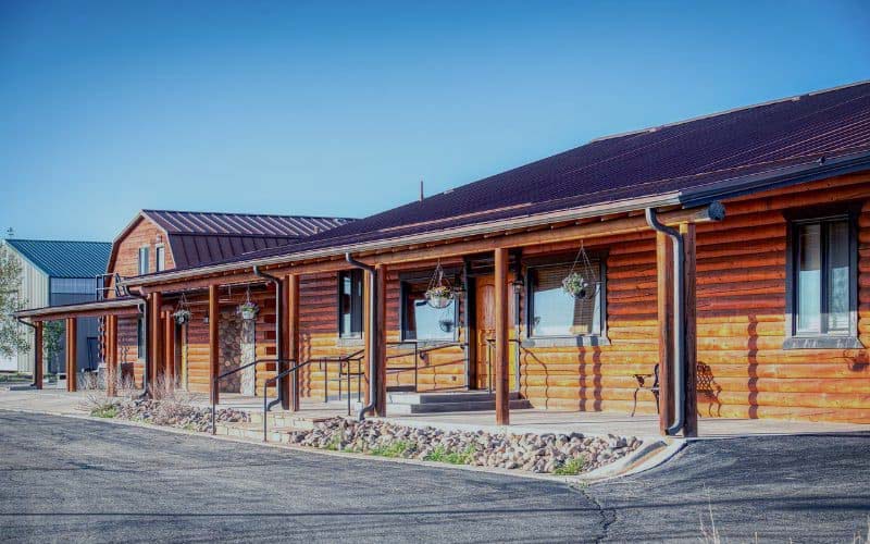 og cabin-style facility with a covered porch and hanging plants.