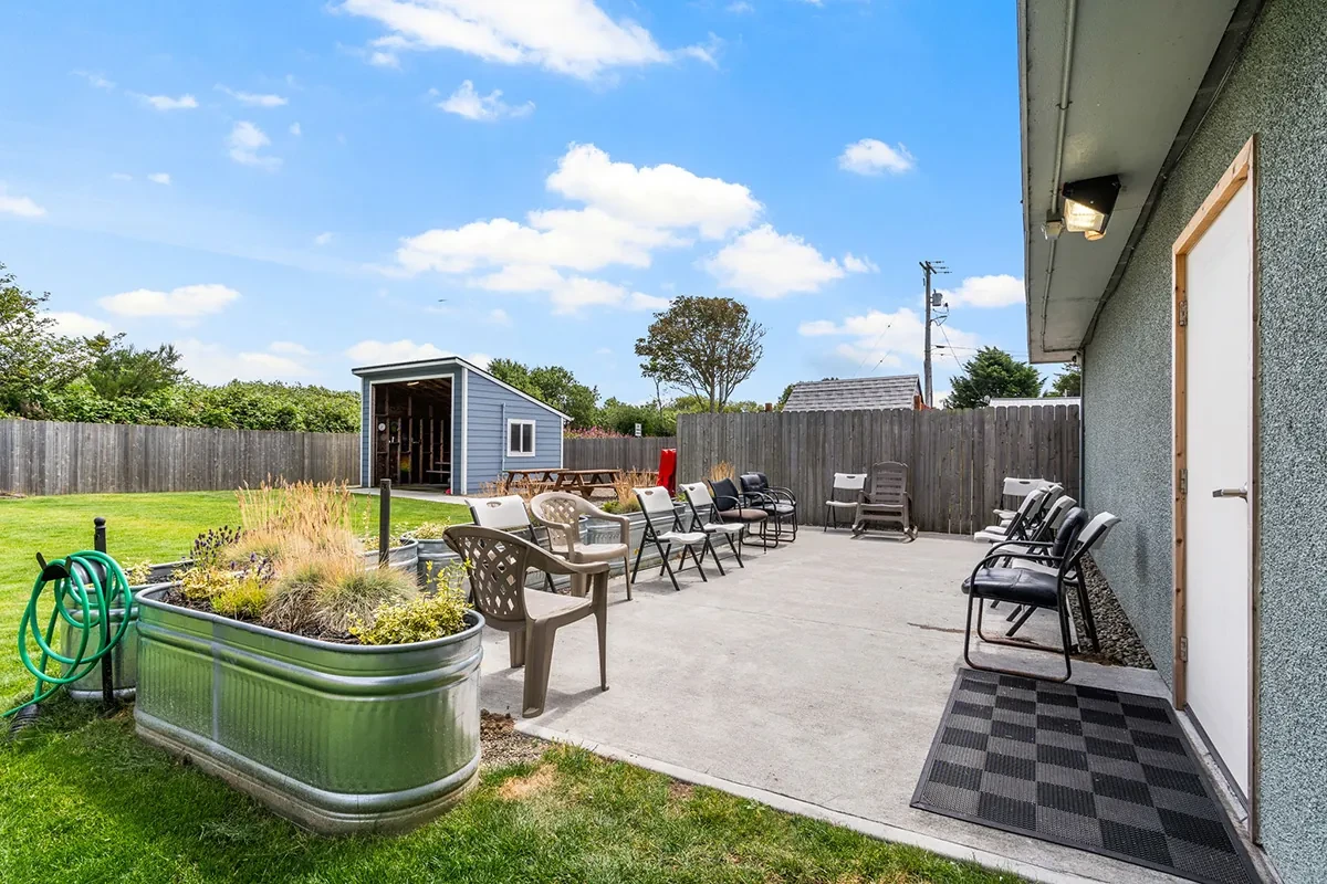 Concrete patio with chairs and small shed