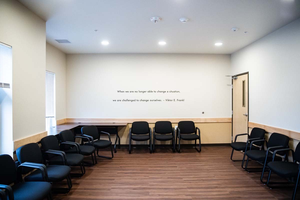Circle of chairs in a bright group room with quote on wall