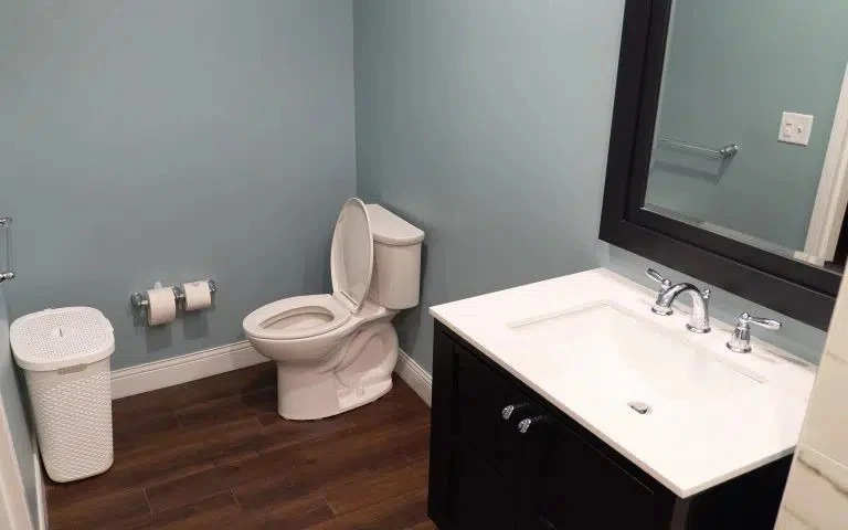 Modern bathroom with vanity and toilet on wood flooring