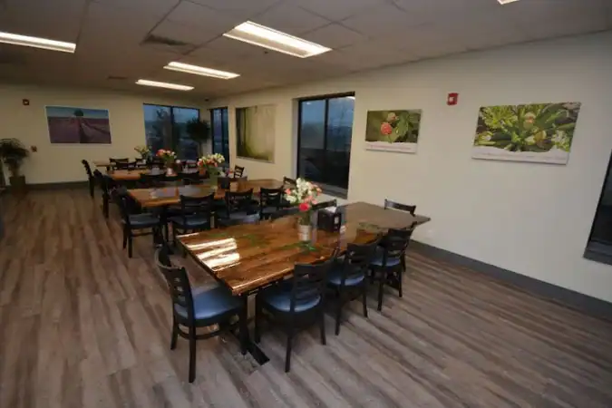 Long dining room with wooden tables and large windows