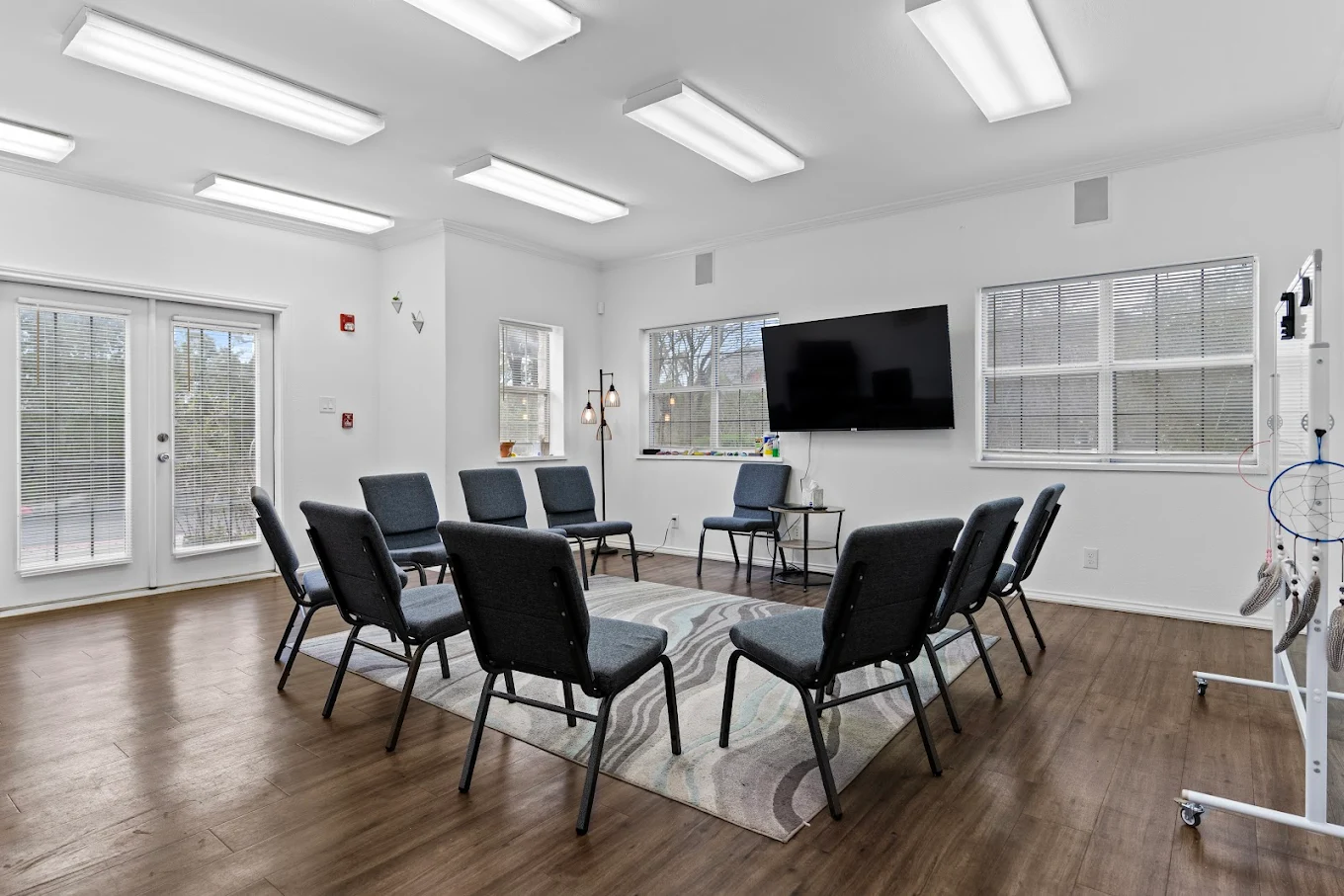 Group therapy room with chairs arranged in circle and TV