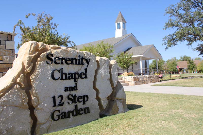 Stone sign reading “Serenity Chapel and 12 Step Garden”