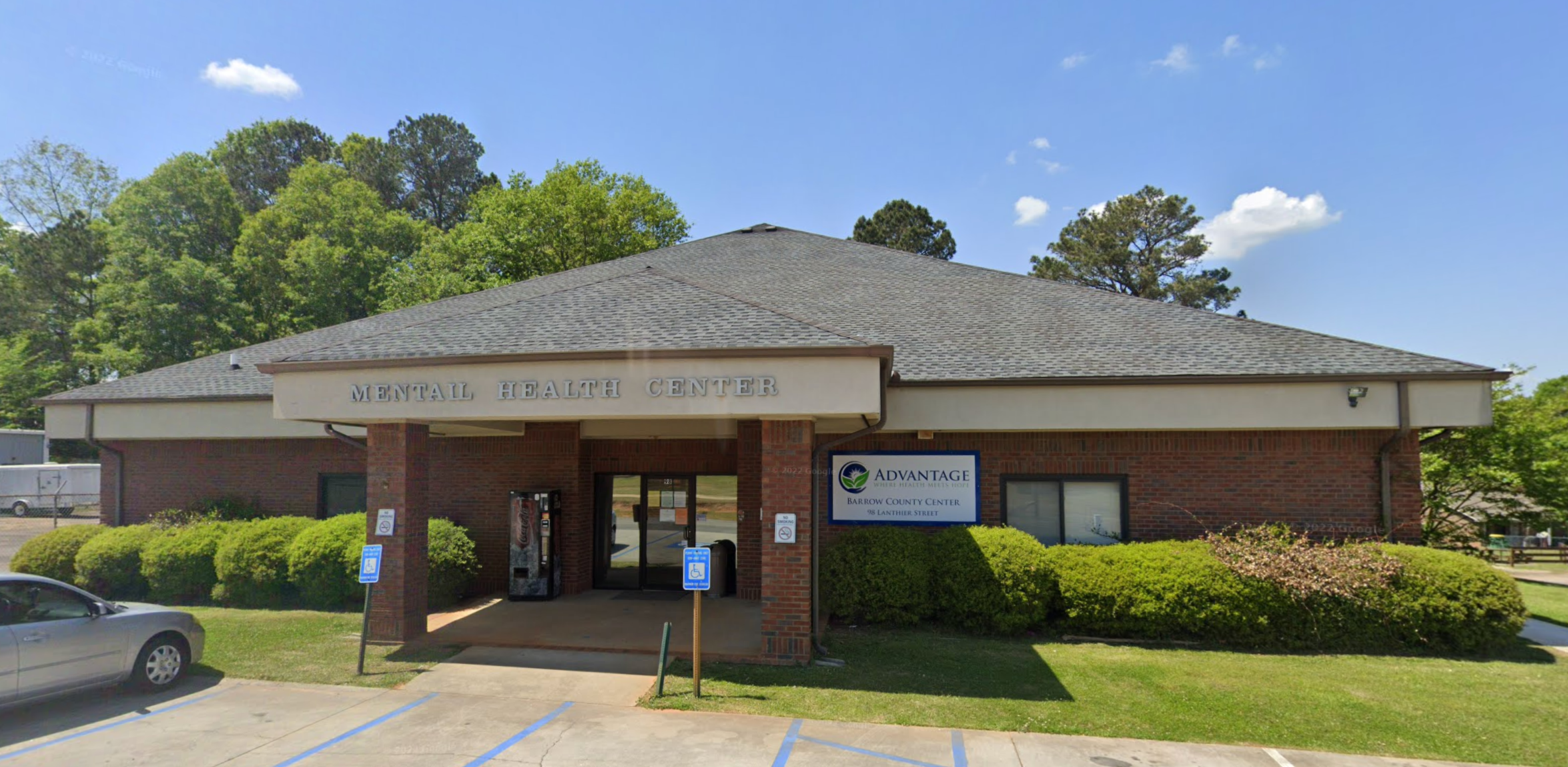 A single-story brick building labeled "Mental Health Center" with a covered entrance and a sign for Advantage Behavioral Health in Barrow County.