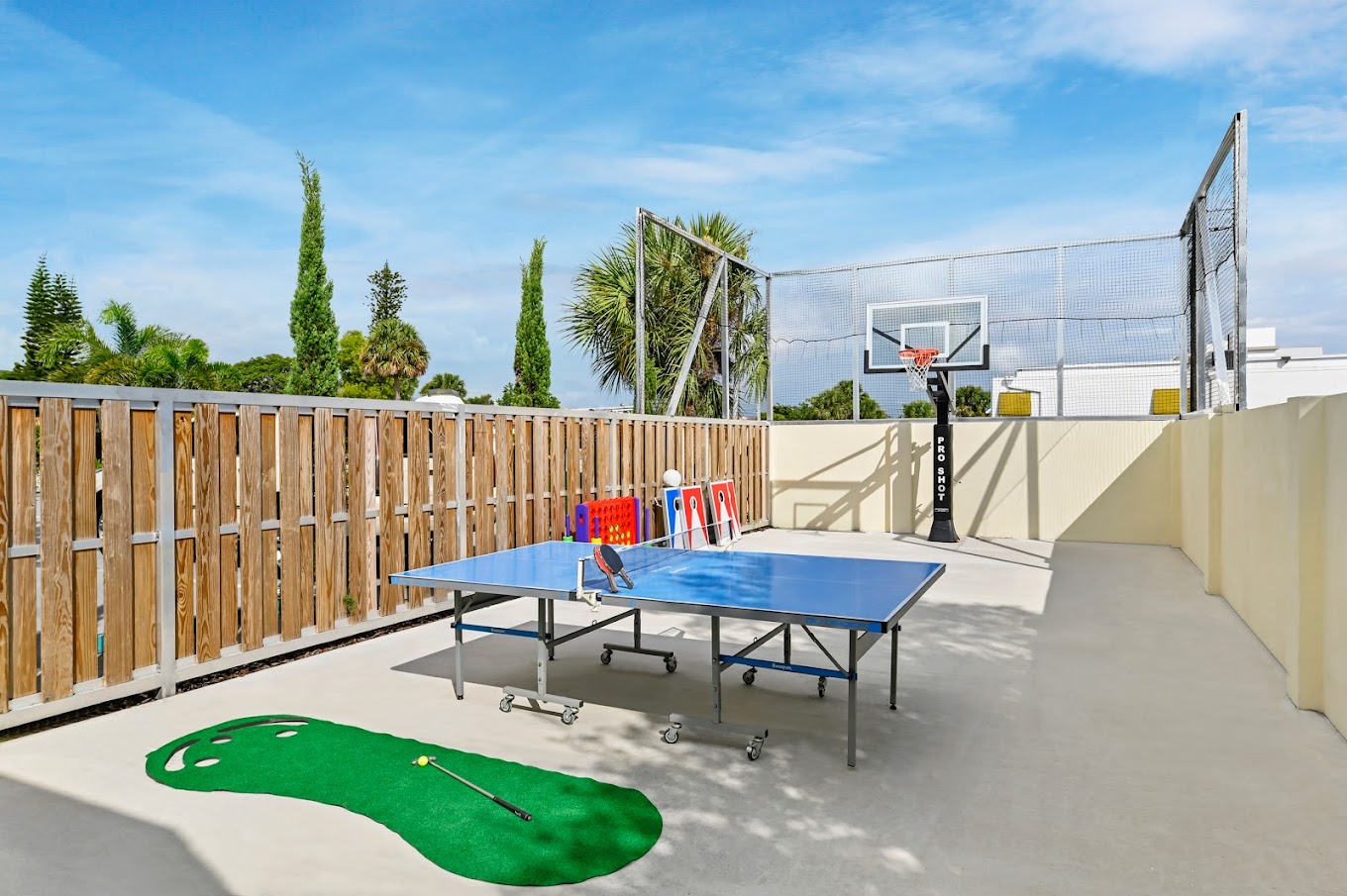 Outdoor recreation space with ping-pong, basketball, and mini-golf.