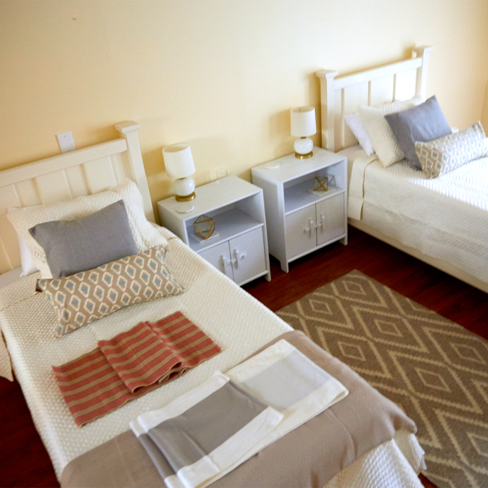 Bedroom with two twin beds, nightstands, and lamps.