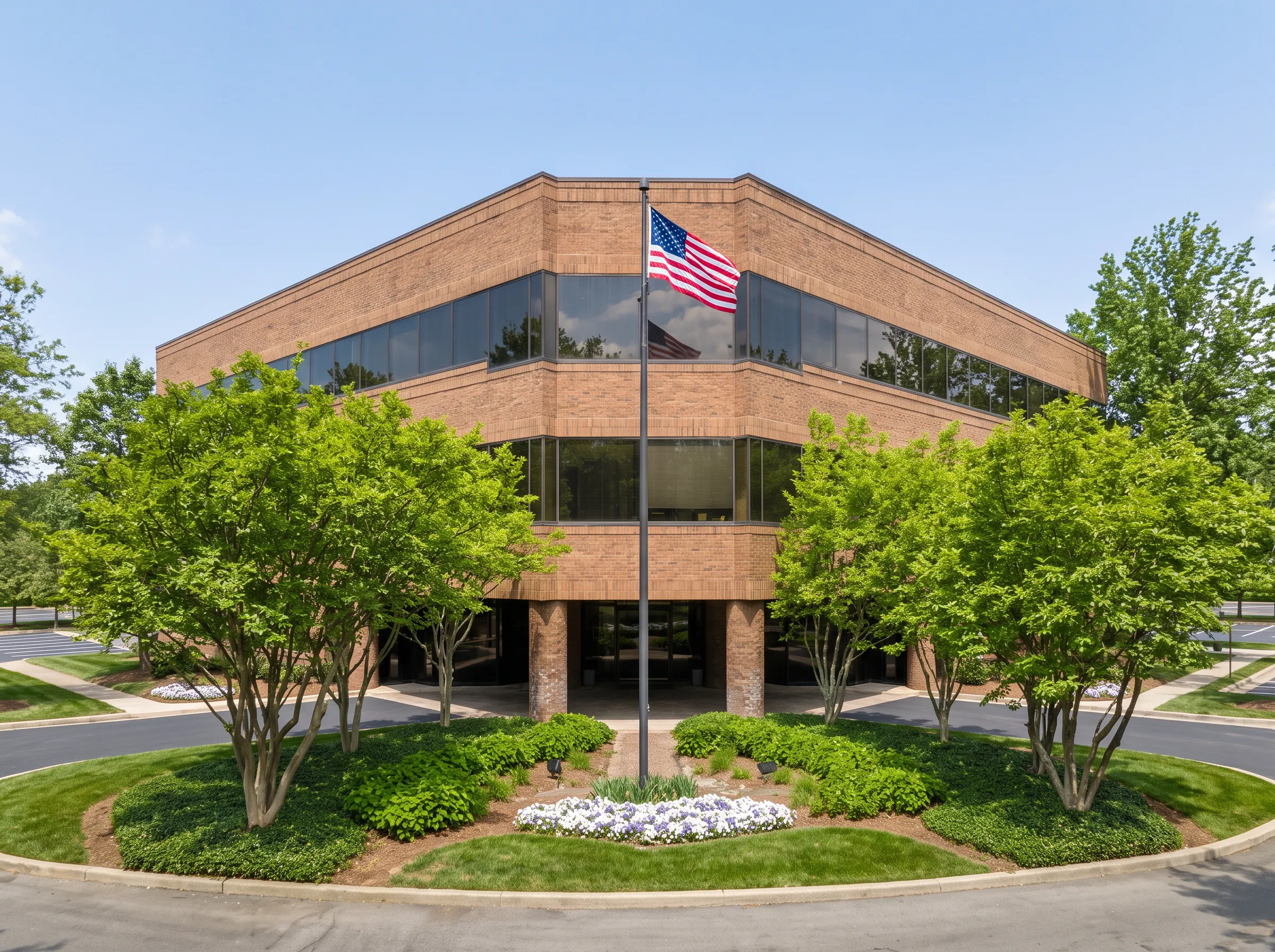 Front of brick facility with flag and landscaped entrance