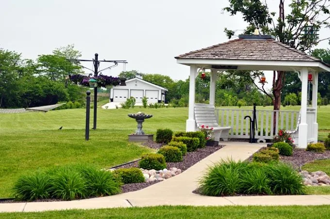 White gazebo surrounded by plants and walkway