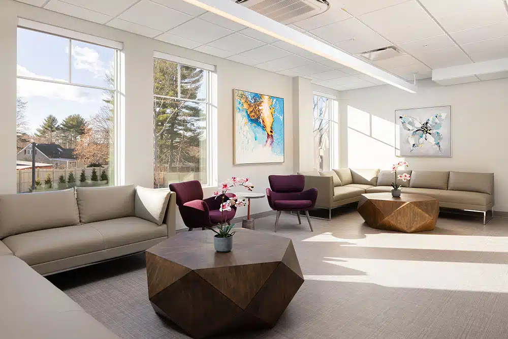 Spacious lounge with sofas, bright windows, and artwork