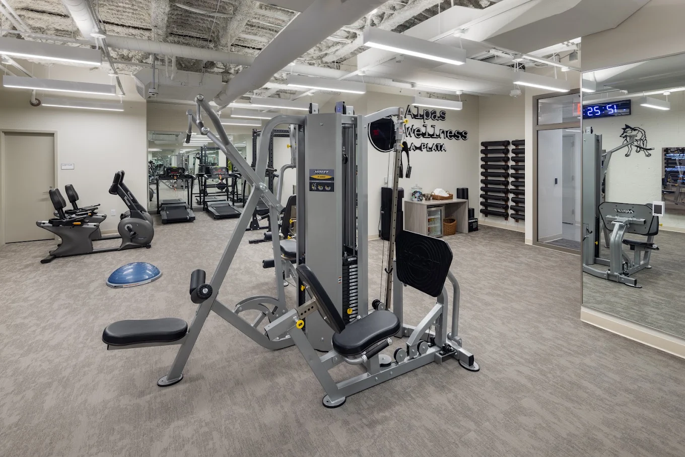 Fitness room with strength machines, exercise bikes, and treadmills.