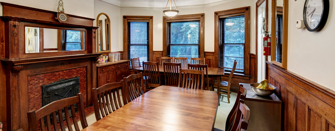 Wood-paneled dining room with long tables and chairs
