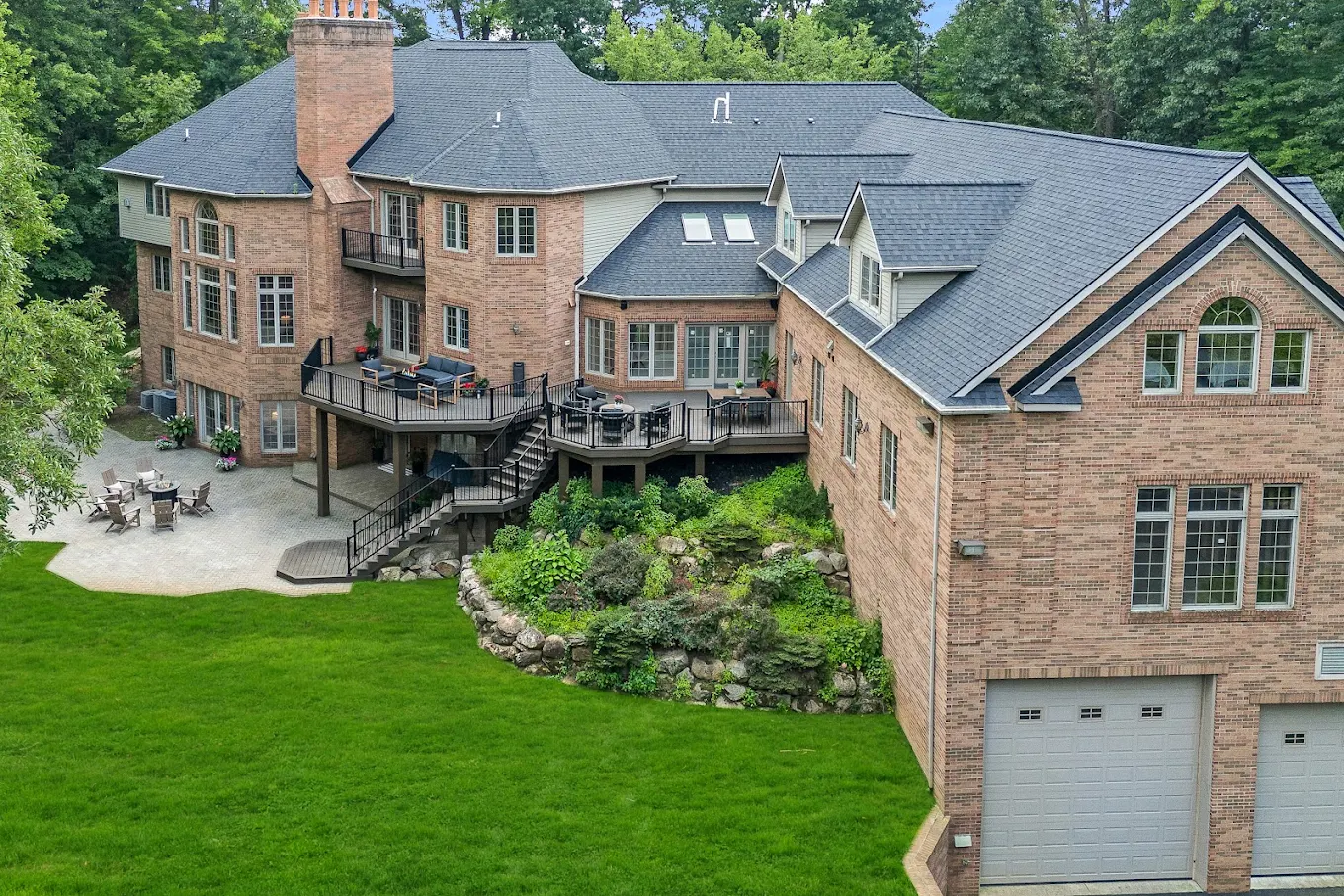 Back of large brick facility with deck and fire pit area