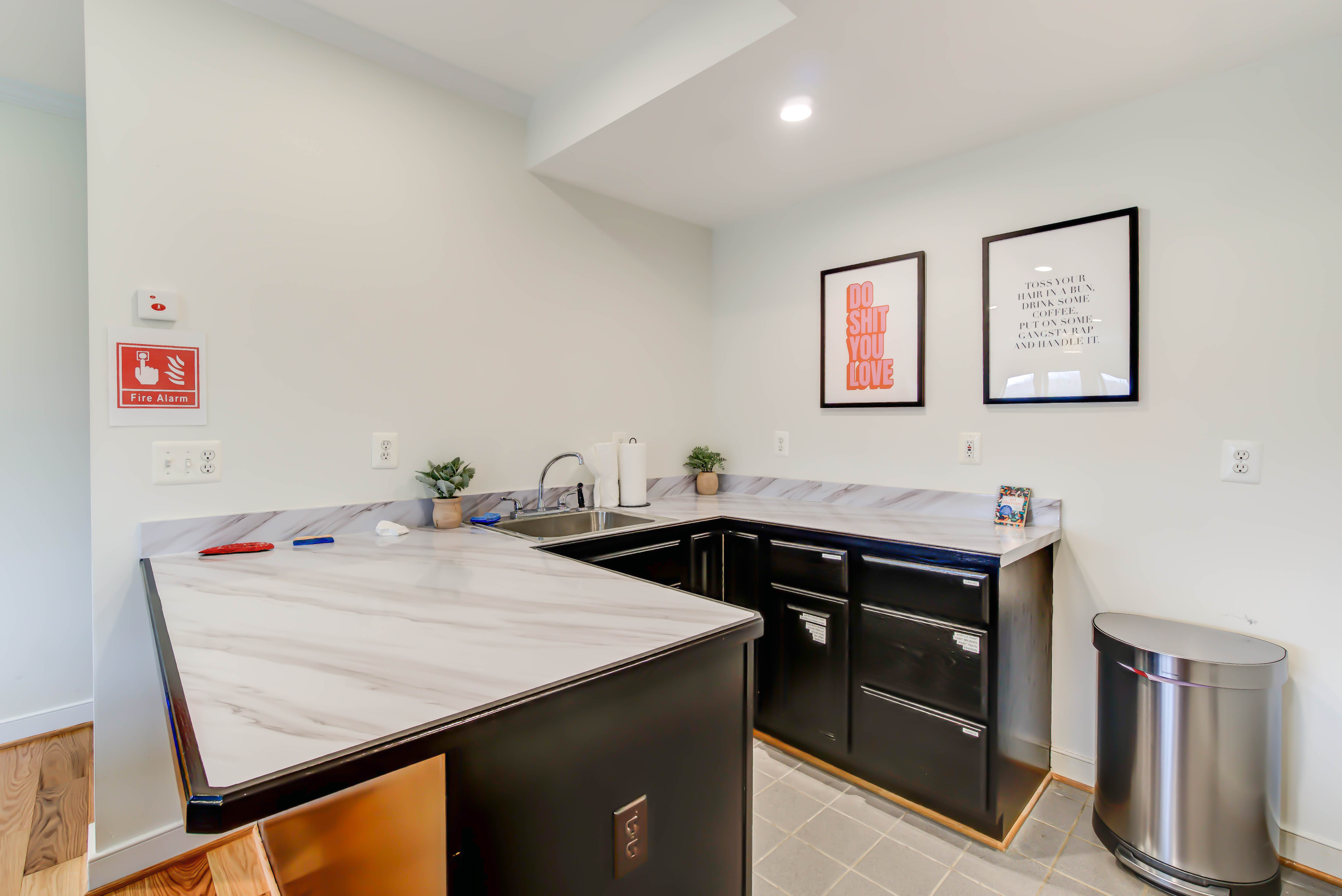 Small kitchenette with marble counters and framed quotes