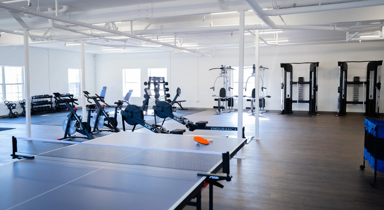Fitness center with cardio equipment, strength machines, free weights, and a ping pong table at Promises Dallas–Fort Worth