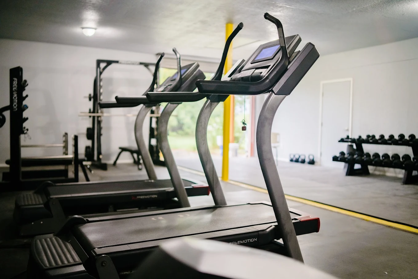 Fitness room with treadmills, weight-training equipment, dumbbells, and kettlebells