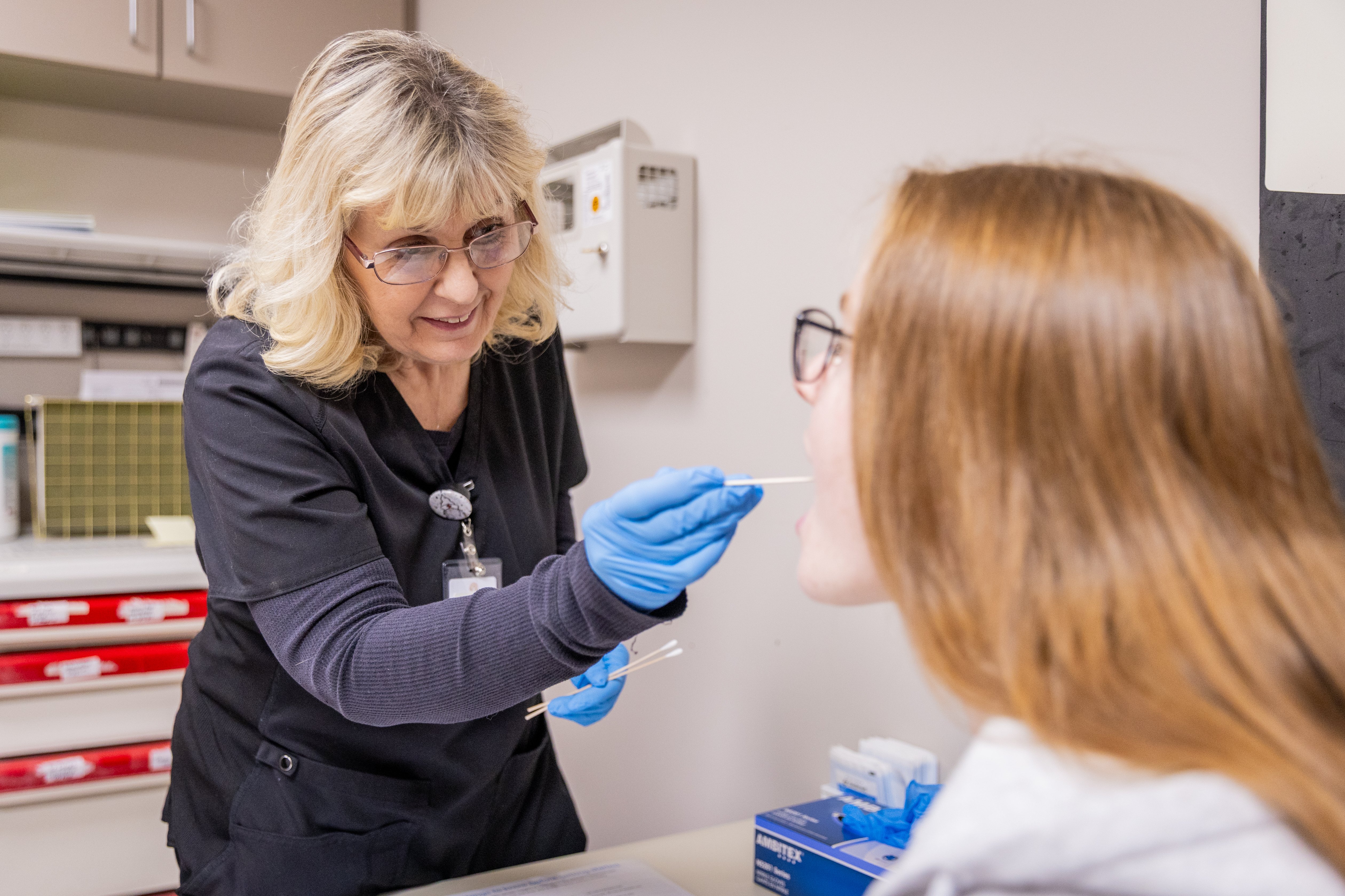 Nurse collecting a swab sample from a patient.