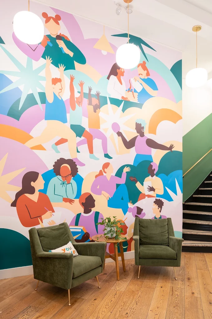 Lobby seating beneath a colorful wall mural