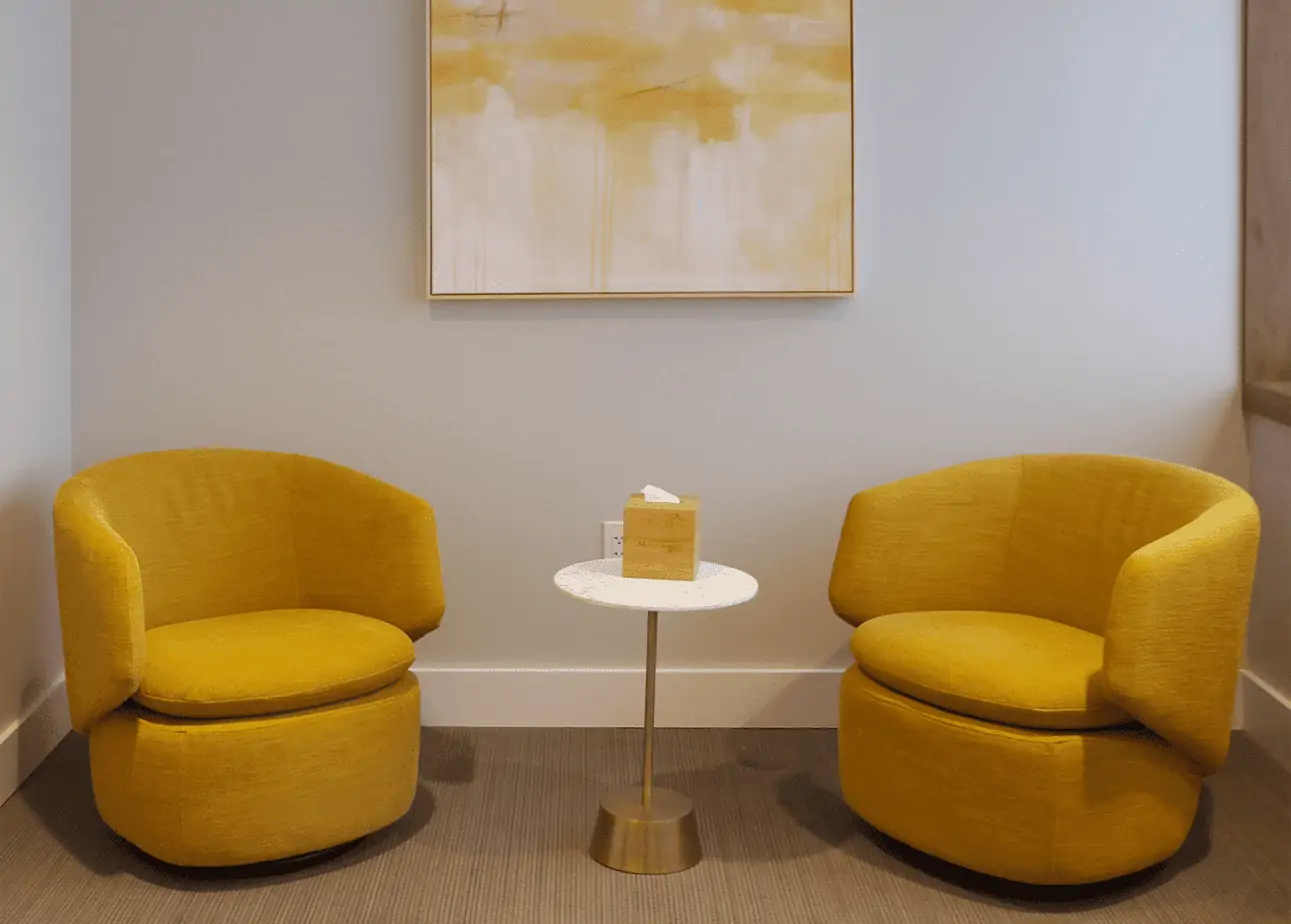 Two yellow chairs with small round table between them
