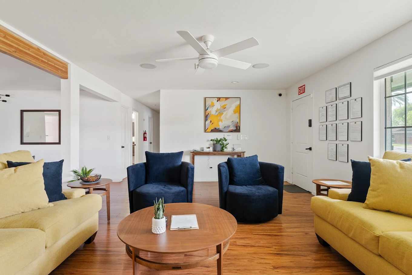 Common area with sofas, blue armchairs, and round coffee table