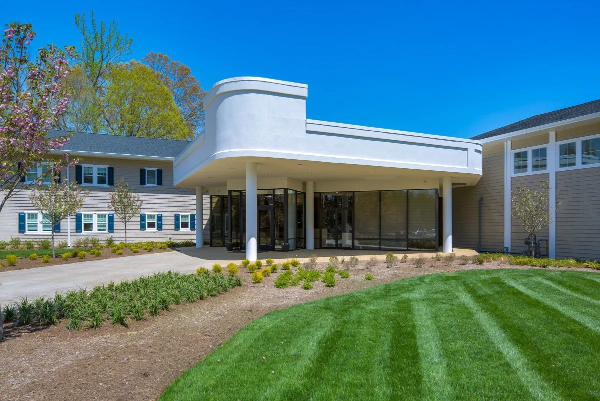 Facility entrance with paved walkway by the lawn.