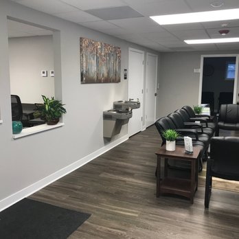 Chairs lined against the wall with side tables and plants