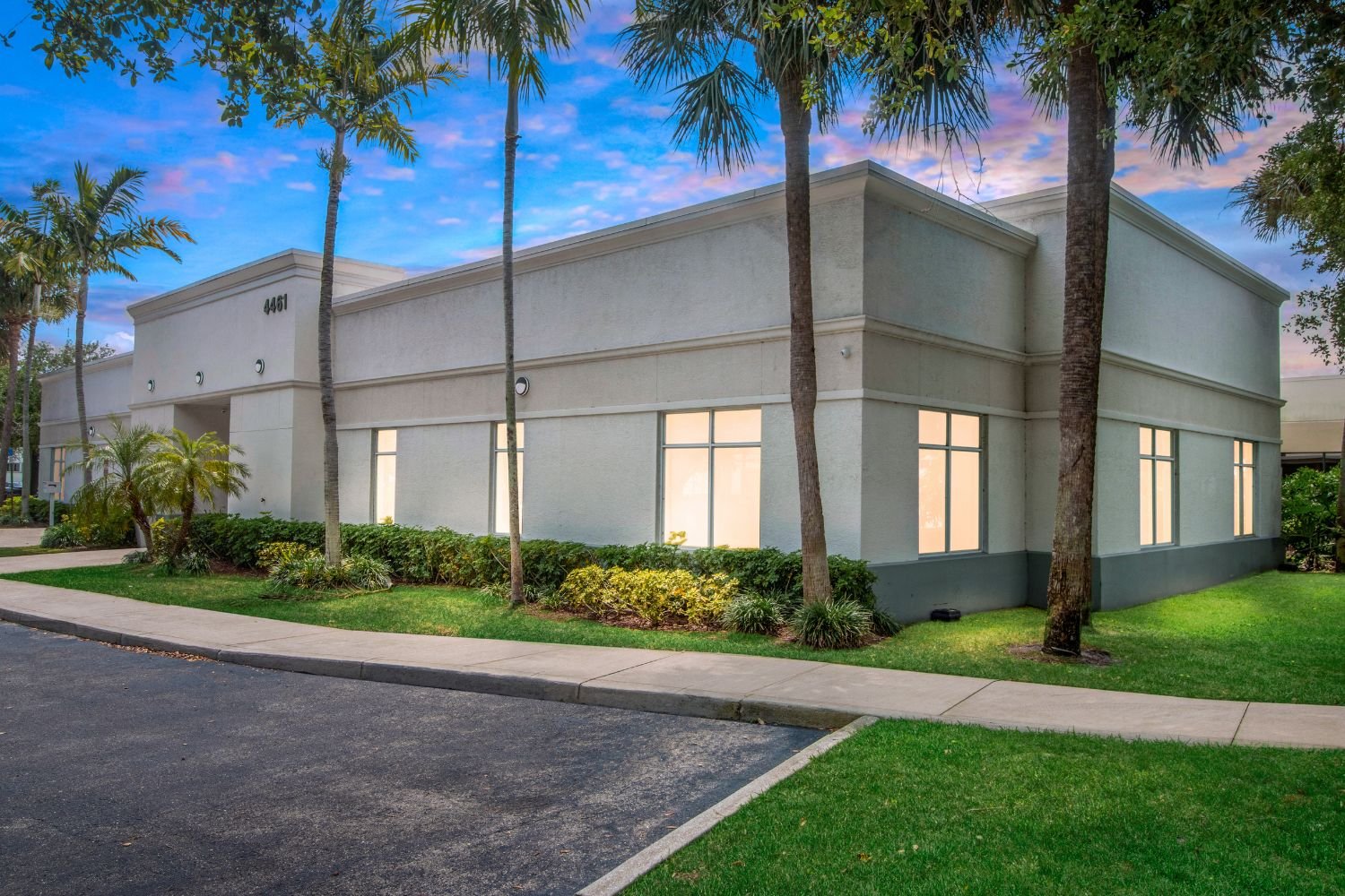 White rehab facility building with palm trees outside