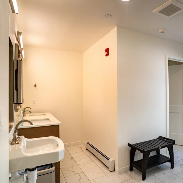 Shared bathroom with sinks and walk-in shower