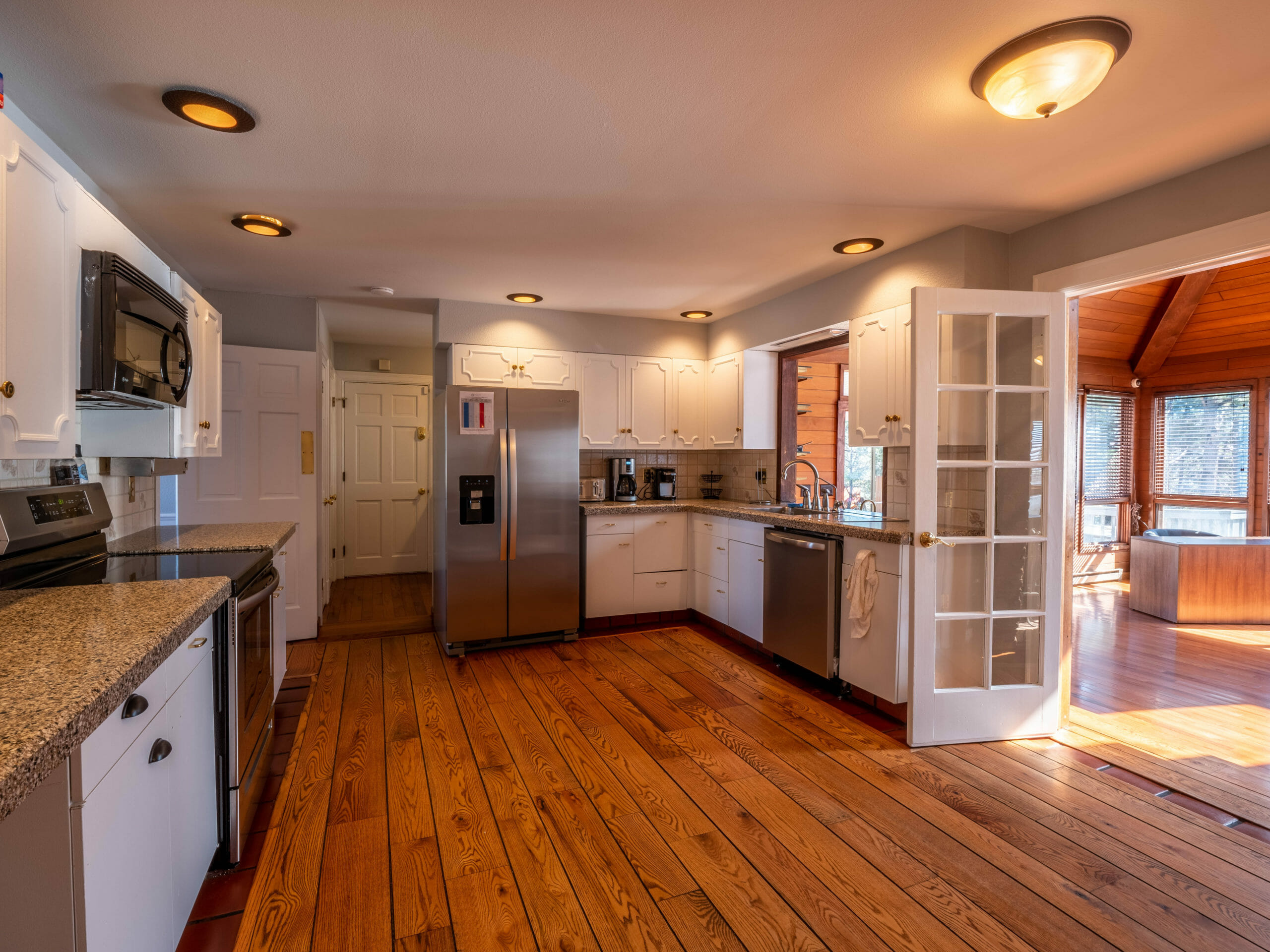 Spacious kitchen with granite counters and white cabinetry