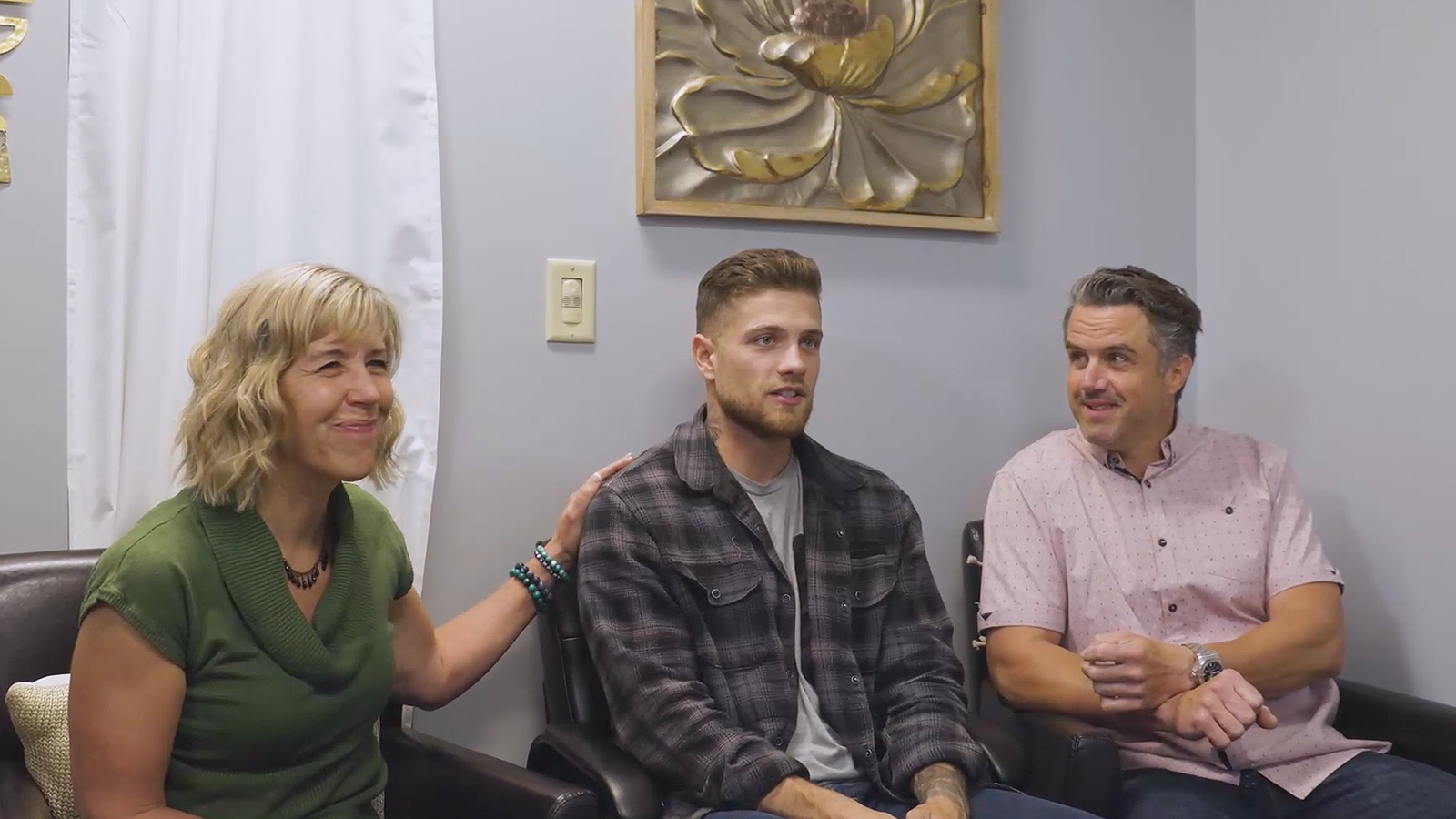People seated in an office with wall decor.