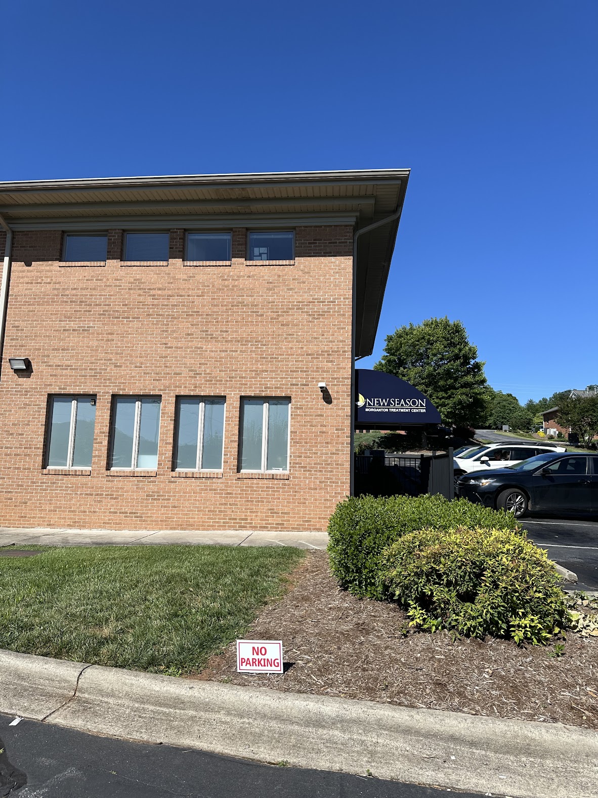 Brick building with New Season awning and no parking sign