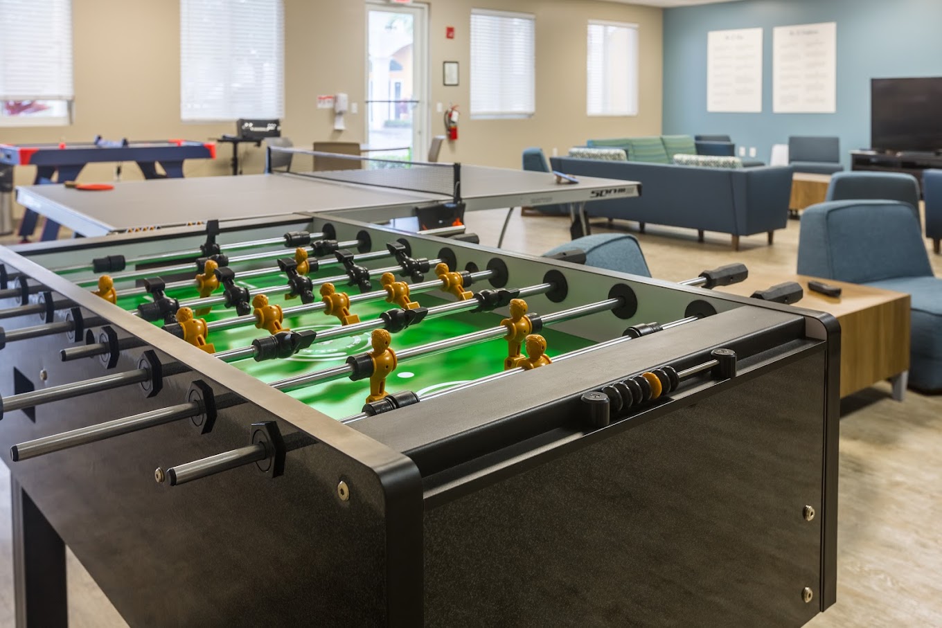 Recreation room with foosball, ping pong, and lounge seating.
