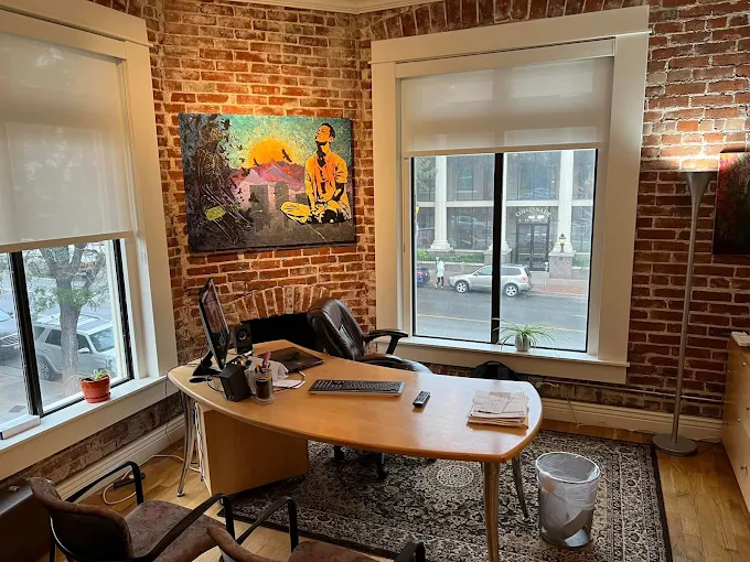 Office with brick walls, desk, and large windows